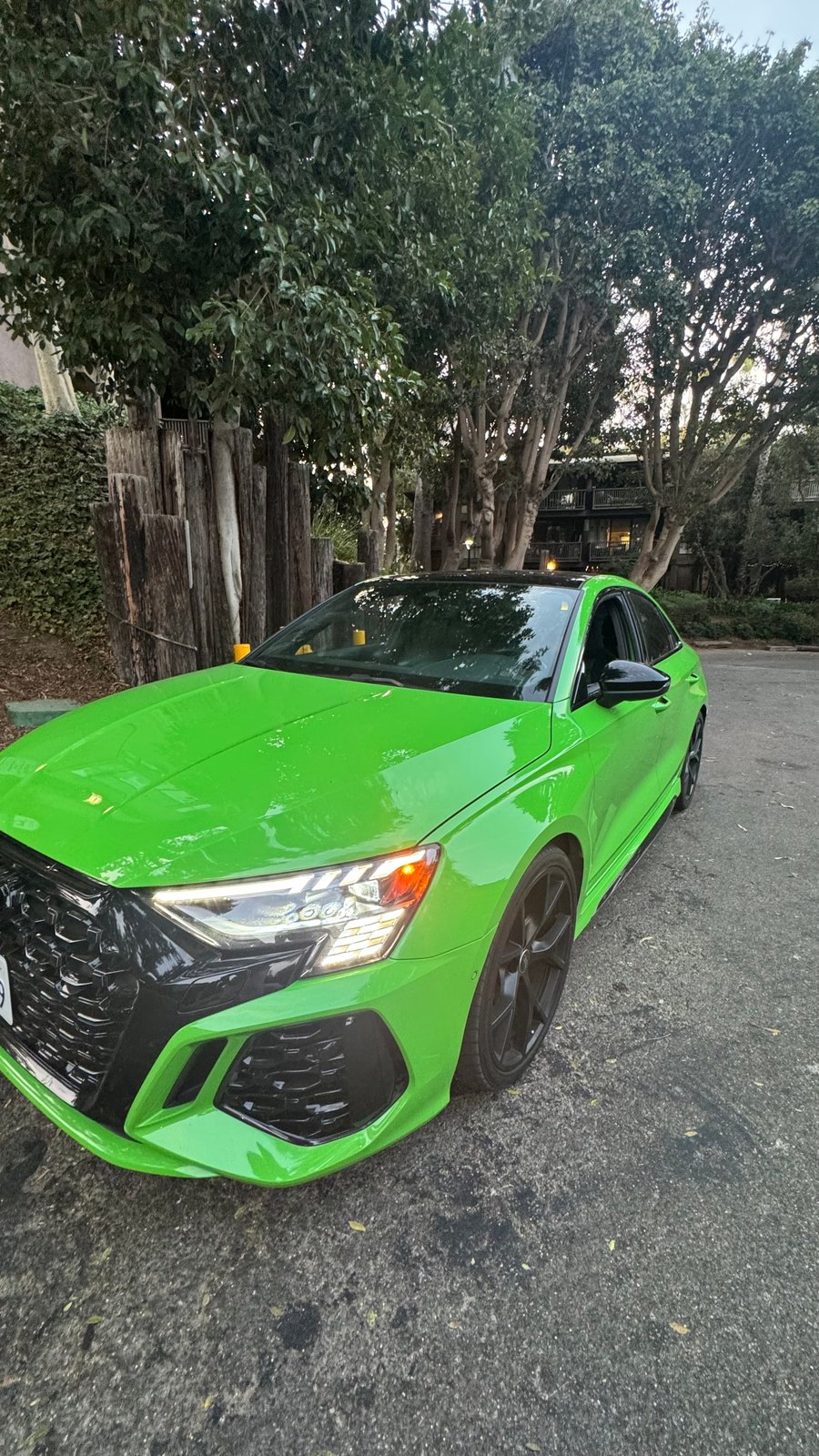 Green Audi RS 3 from a front three-quarter on a residential street
