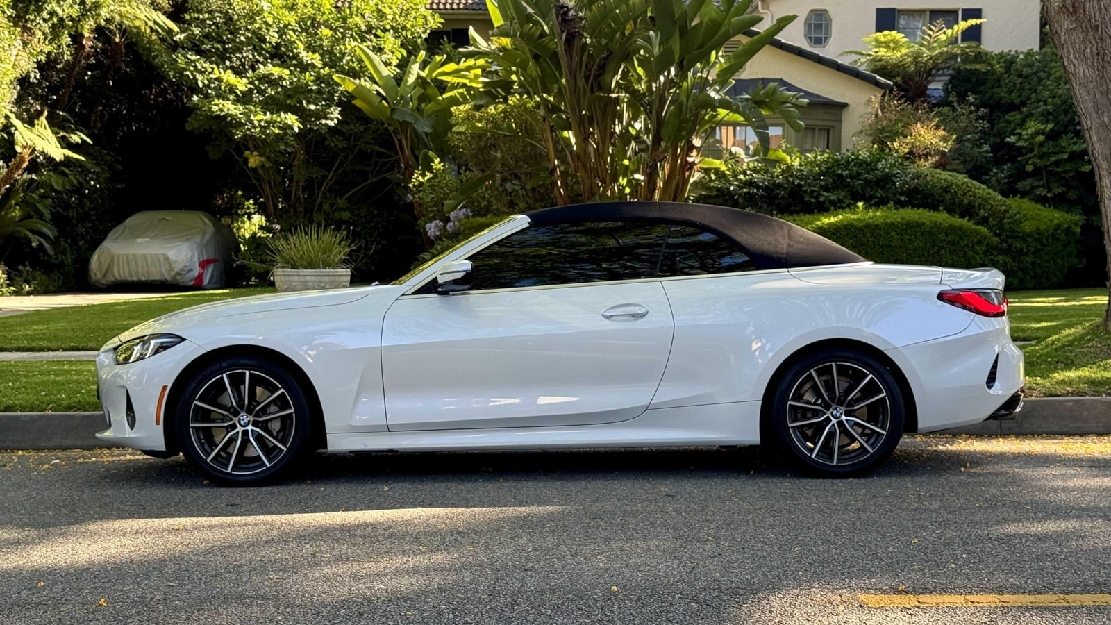 White BMW 430i convertible in profile with the roof raised