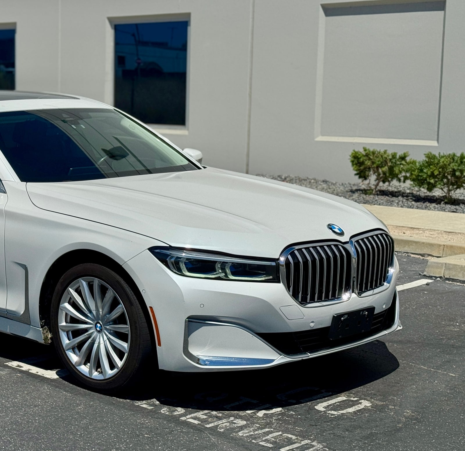 White BMW 7 Series seen close on the nose, kidney grille and headlight