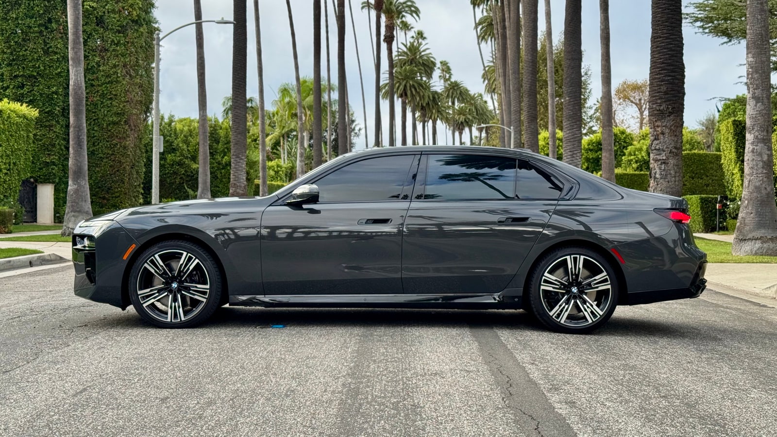 Grey BMW 760i in profile on a residential street
