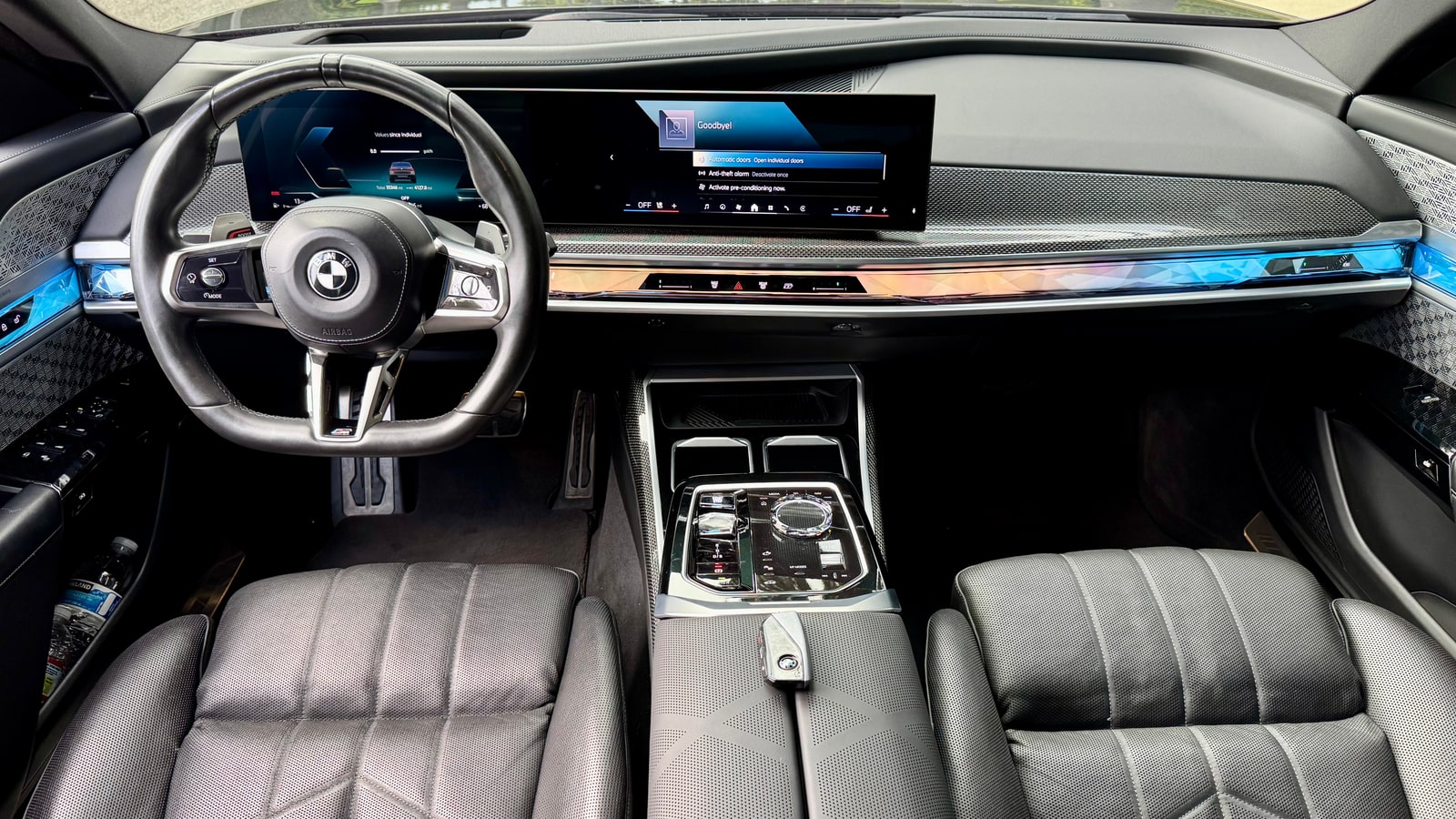 Curved display and lit interaction bar across the dashboard of the BMW 760i