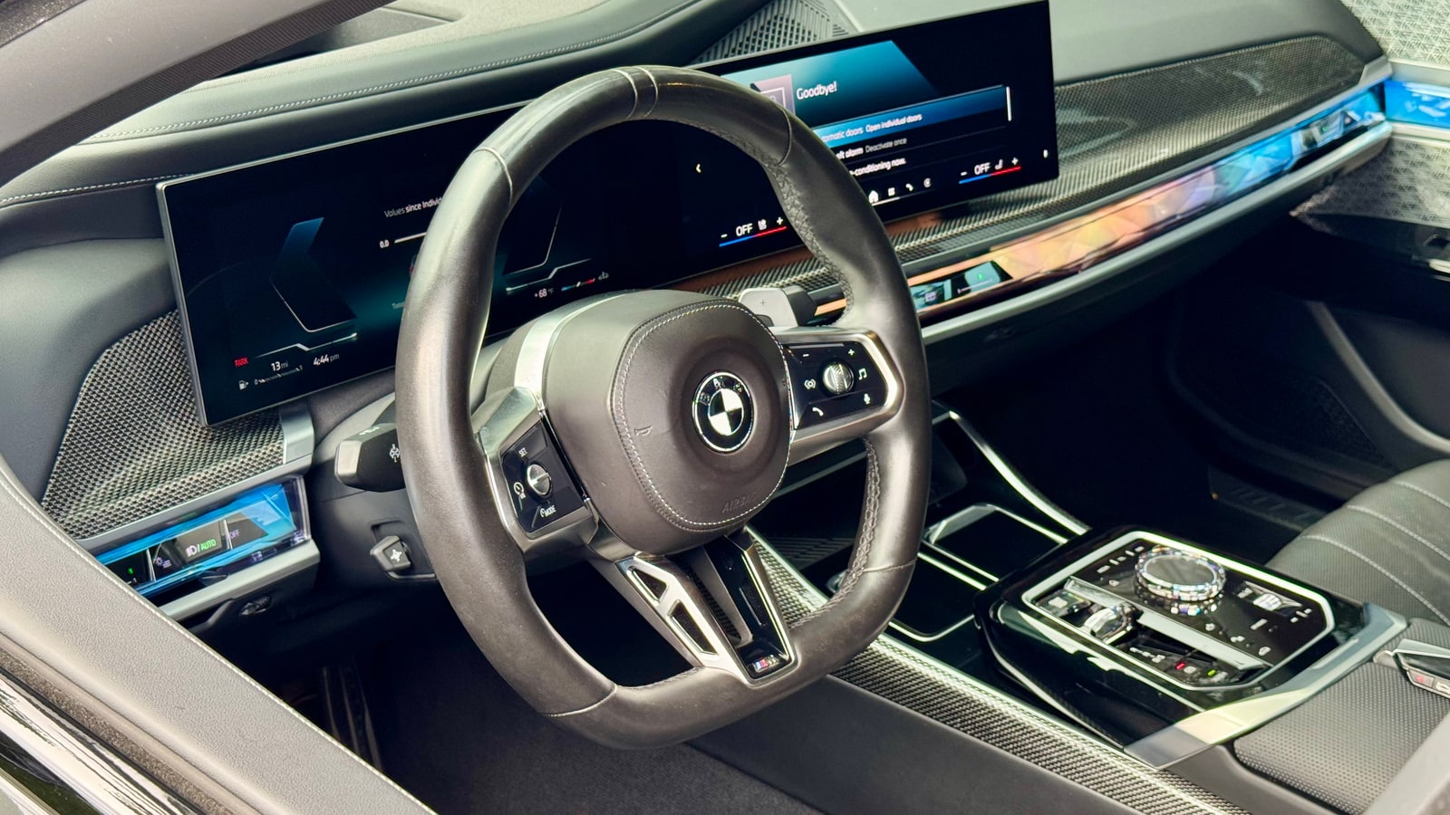 Steering wheel and curved display of the BMW 760i seen through the driver door