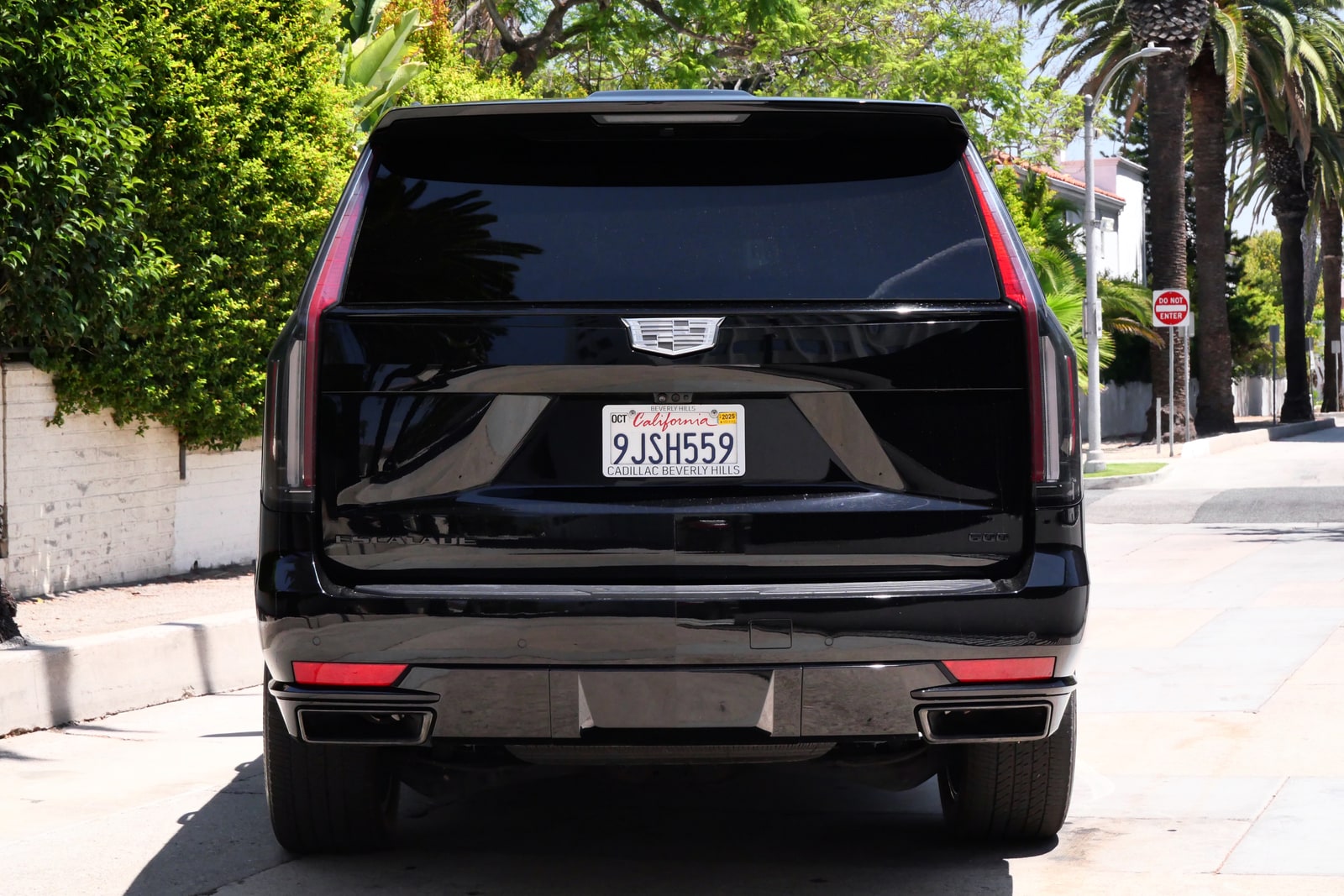 Rear of the black Cadillac Escalade with its vertical tail light blades