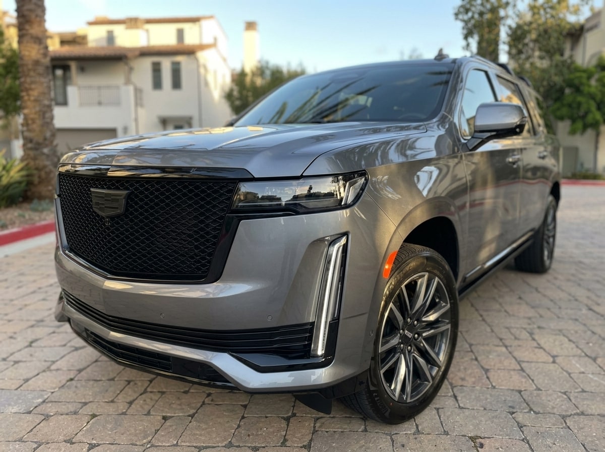 Blacked-out mesh grille and vertical headlamp blade of the grey Cadillac Escalade ESV
