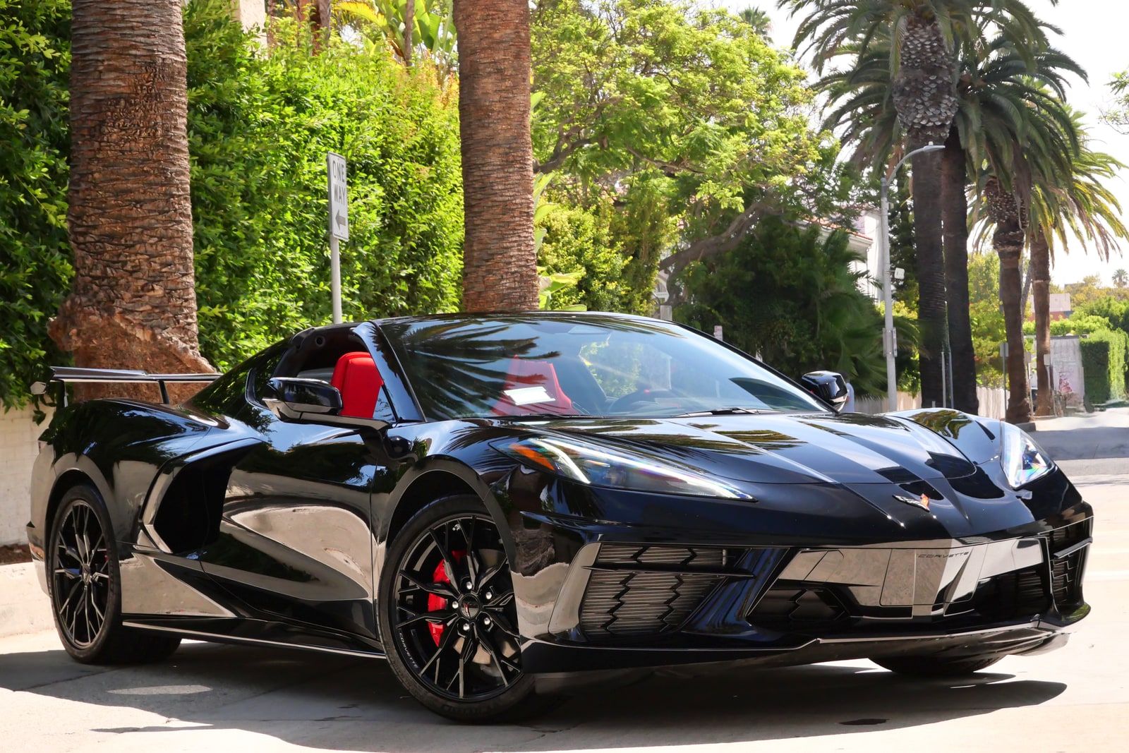 Black Chevrolet Corvette C8 nose-on, low front three-quarter, on a Los Angeles street
