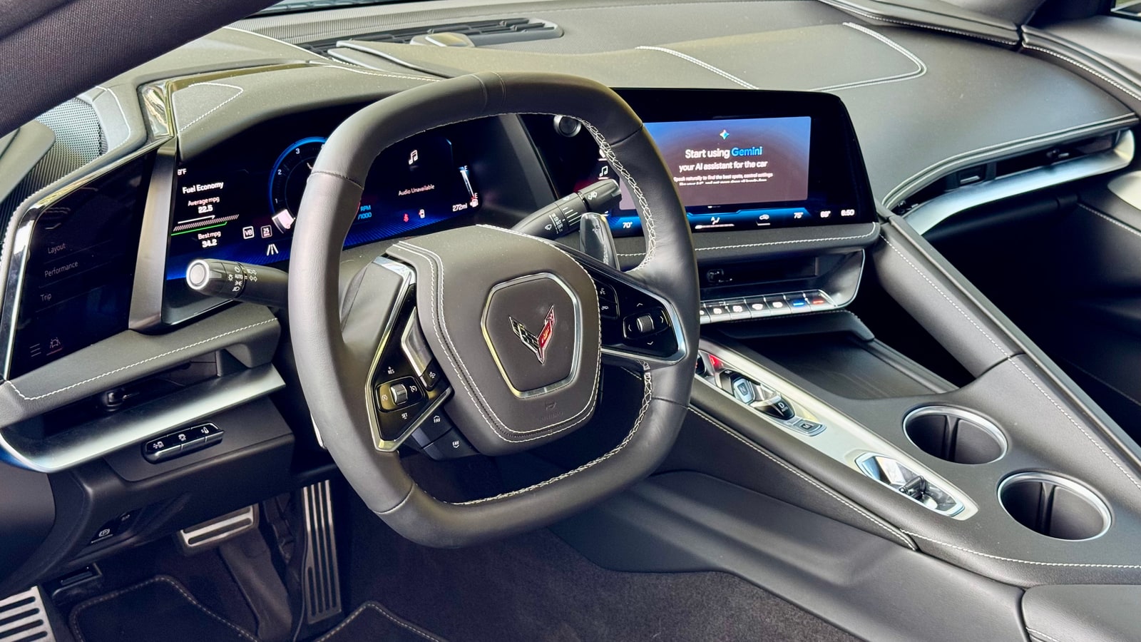 Cockpit of the blue Chevrolet Corvette with its squared wheel and screens