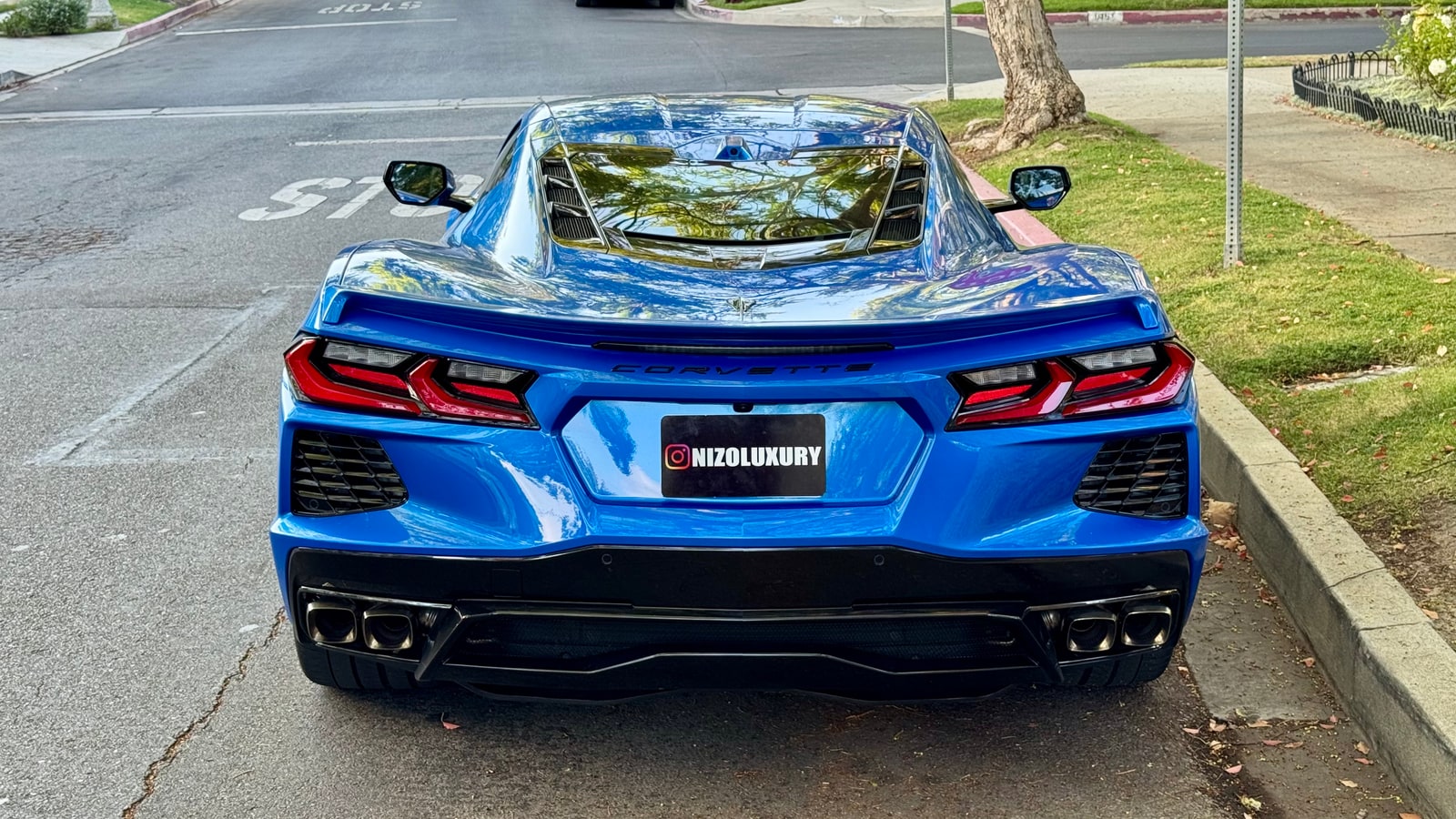 Rear of the blue Chevrolet Corvette with its four tail lights and quad exhausts