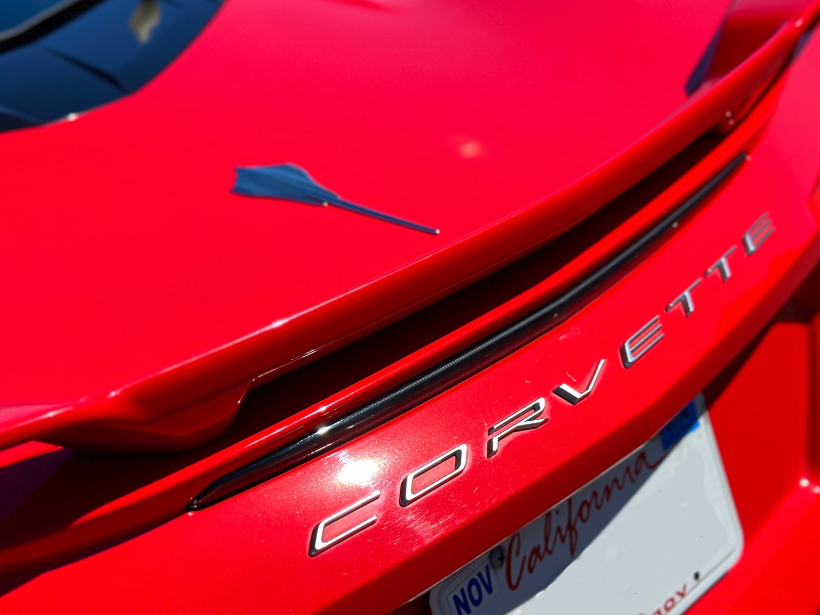 CORVETTE lettering across the rear deck of the red Chevrolet