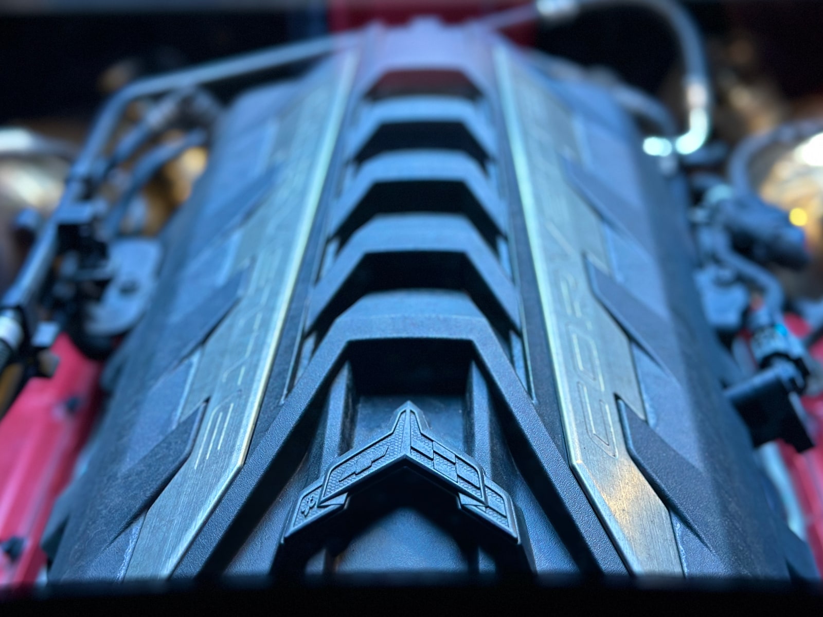 The mid-mounted V8 of the Corvette under its cover