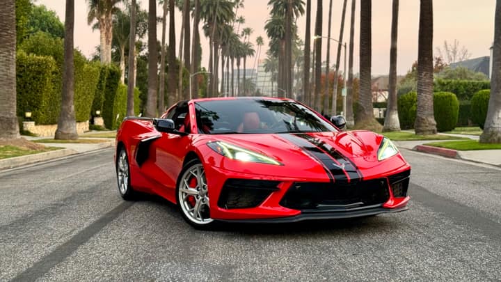 Red Chevrolet Corvette C8 convertible on a palm-lined street