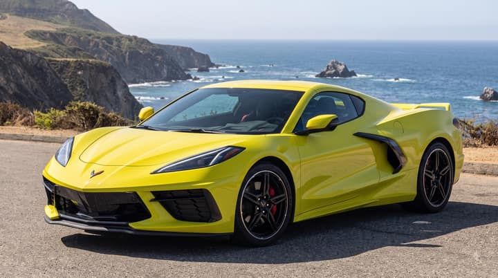 Yellow Chevrolet Corvette on a coastal road high above the Pacific