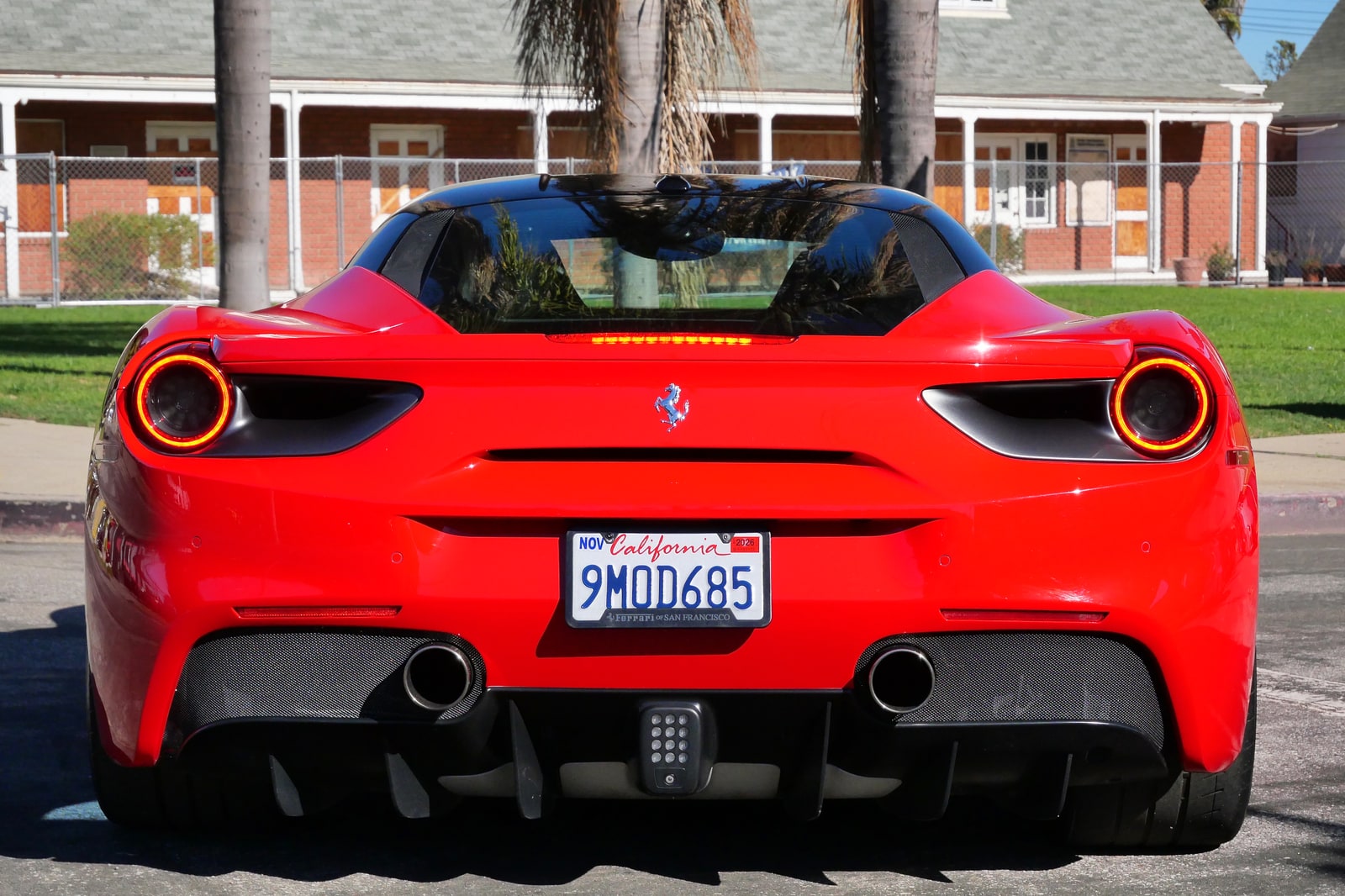 Rear view of the red Ferrari 488 GTB with round tail lights and quad exhausts