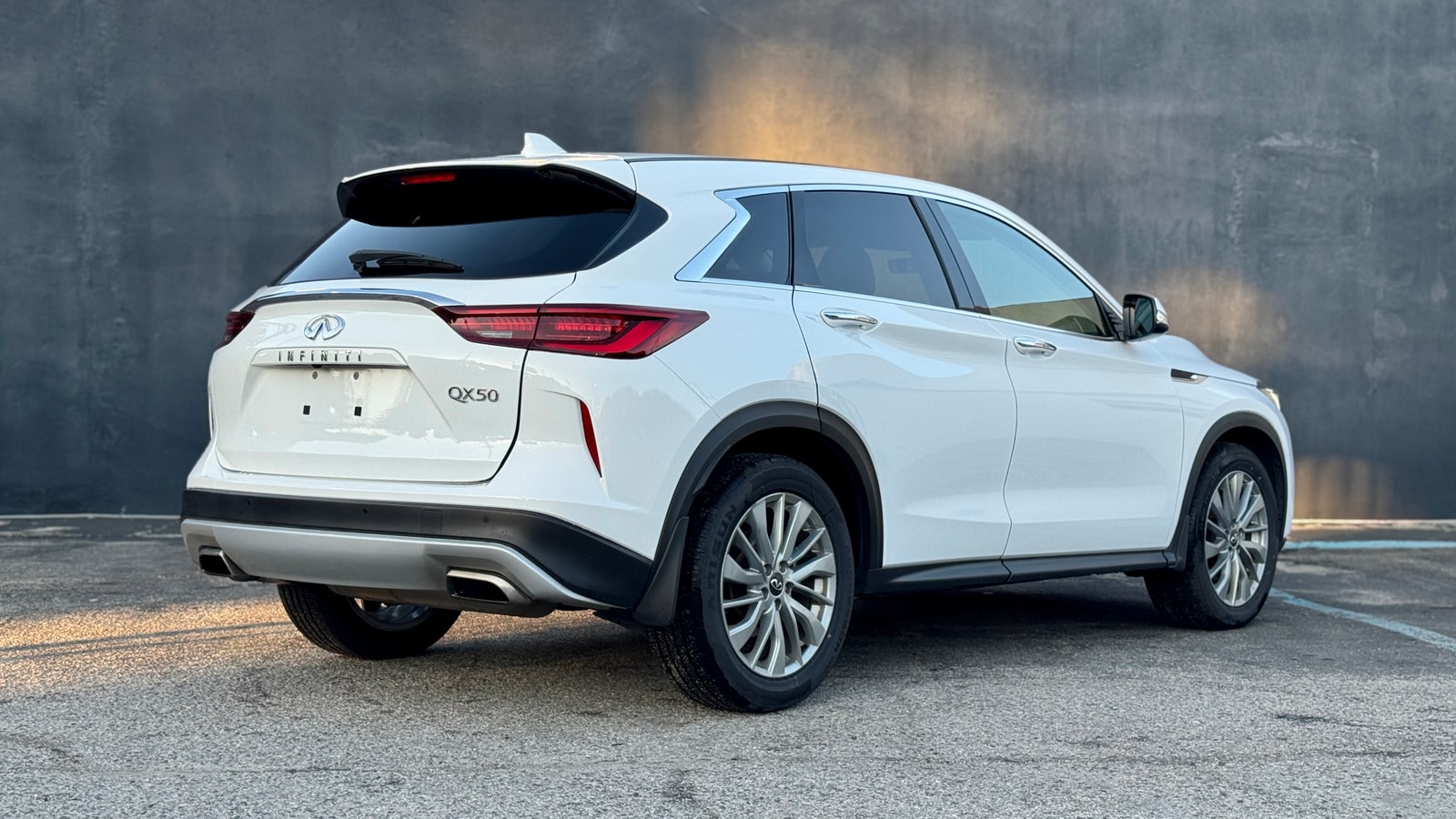 White Infiniti QX50 from the rear three-quarter