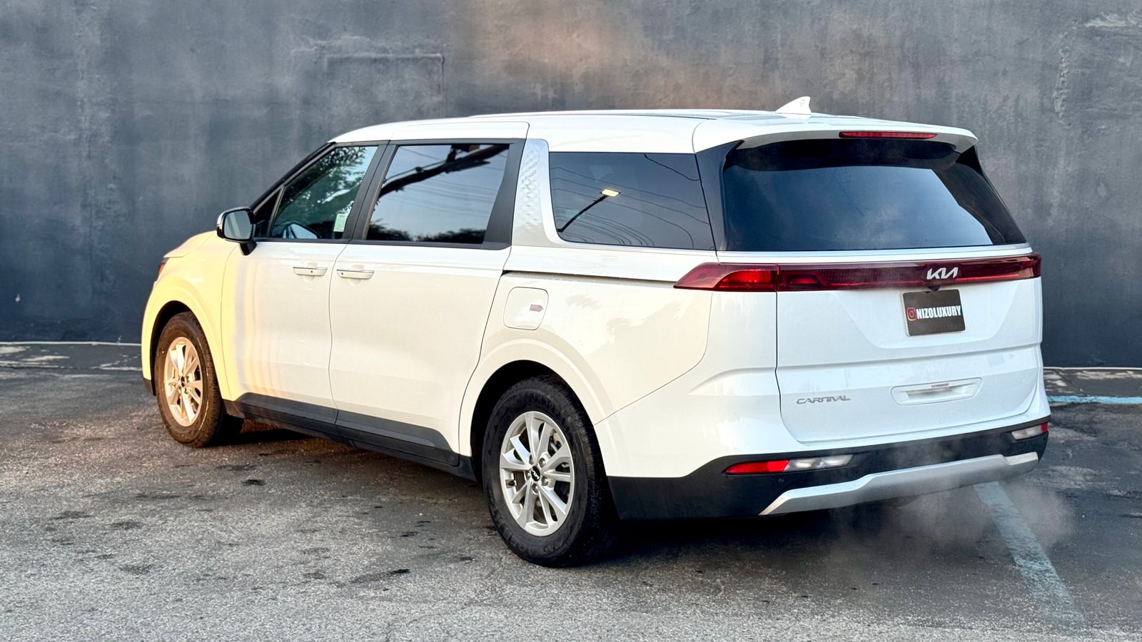 White Kia Carnival from the rear three-quarter