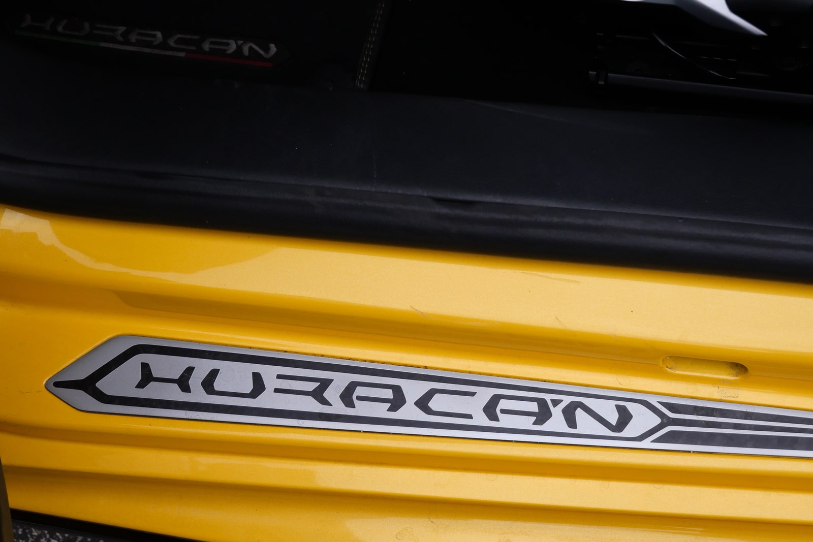 HURACÁN name plate set into the door sill of the yellow Lamborghini