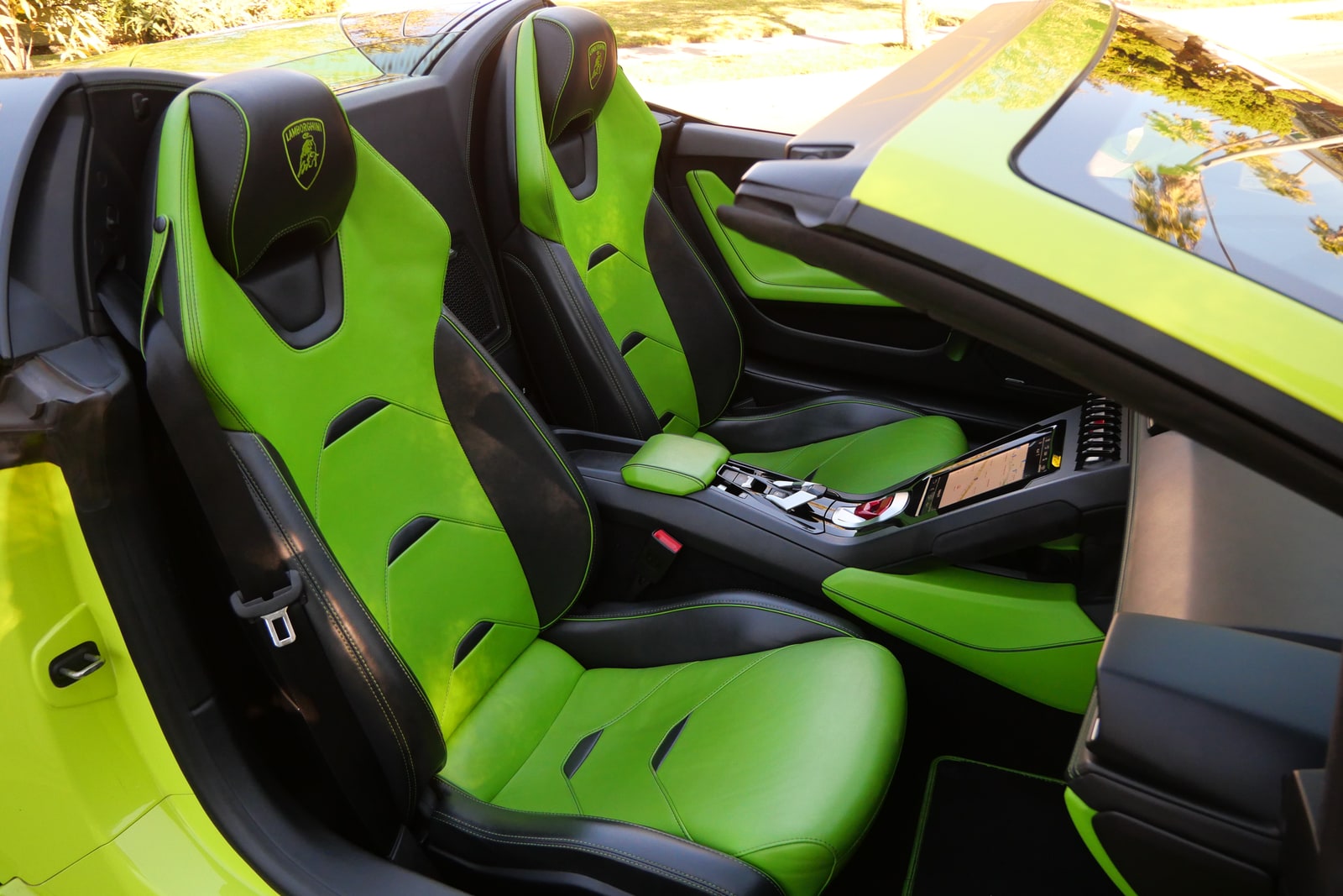 Green leather seats of the Huracán Evo Spyder with the roof open to the sky