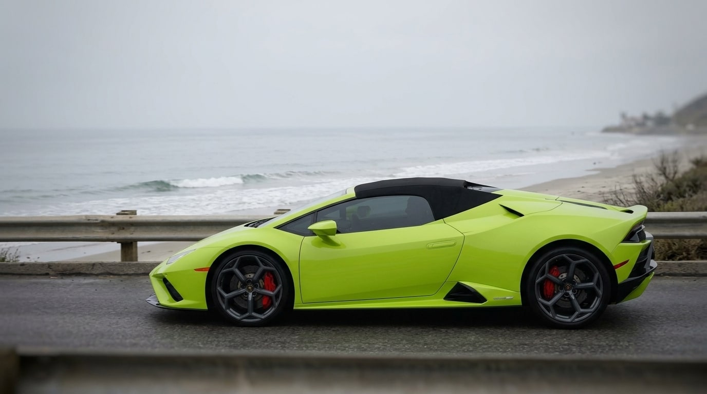 Green Lamborghini Huracán Evo Spider with its fabric roof up on the Pacific Coast Highway under a grey marine layer