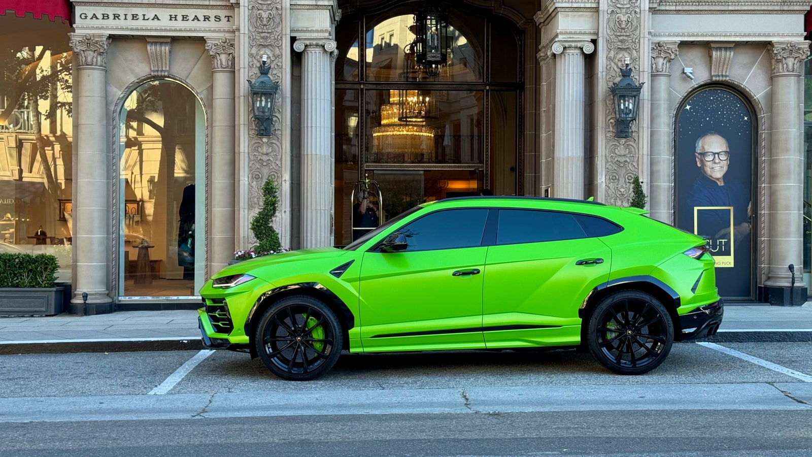 Profile of the green Lamborghini Urus outside a Beverly Hills boutique