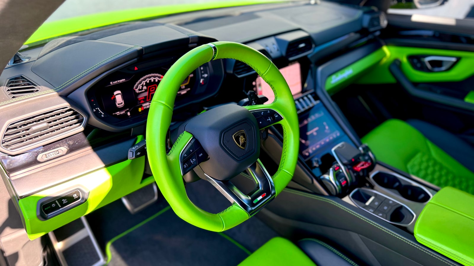 Green leather steering wheel of the Lamborghini Urus with the crest on the boss