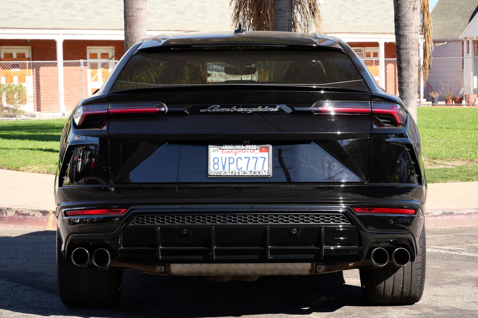 Rear of the black Lamborghini Urus with the Lamborghini script and quad exhausts