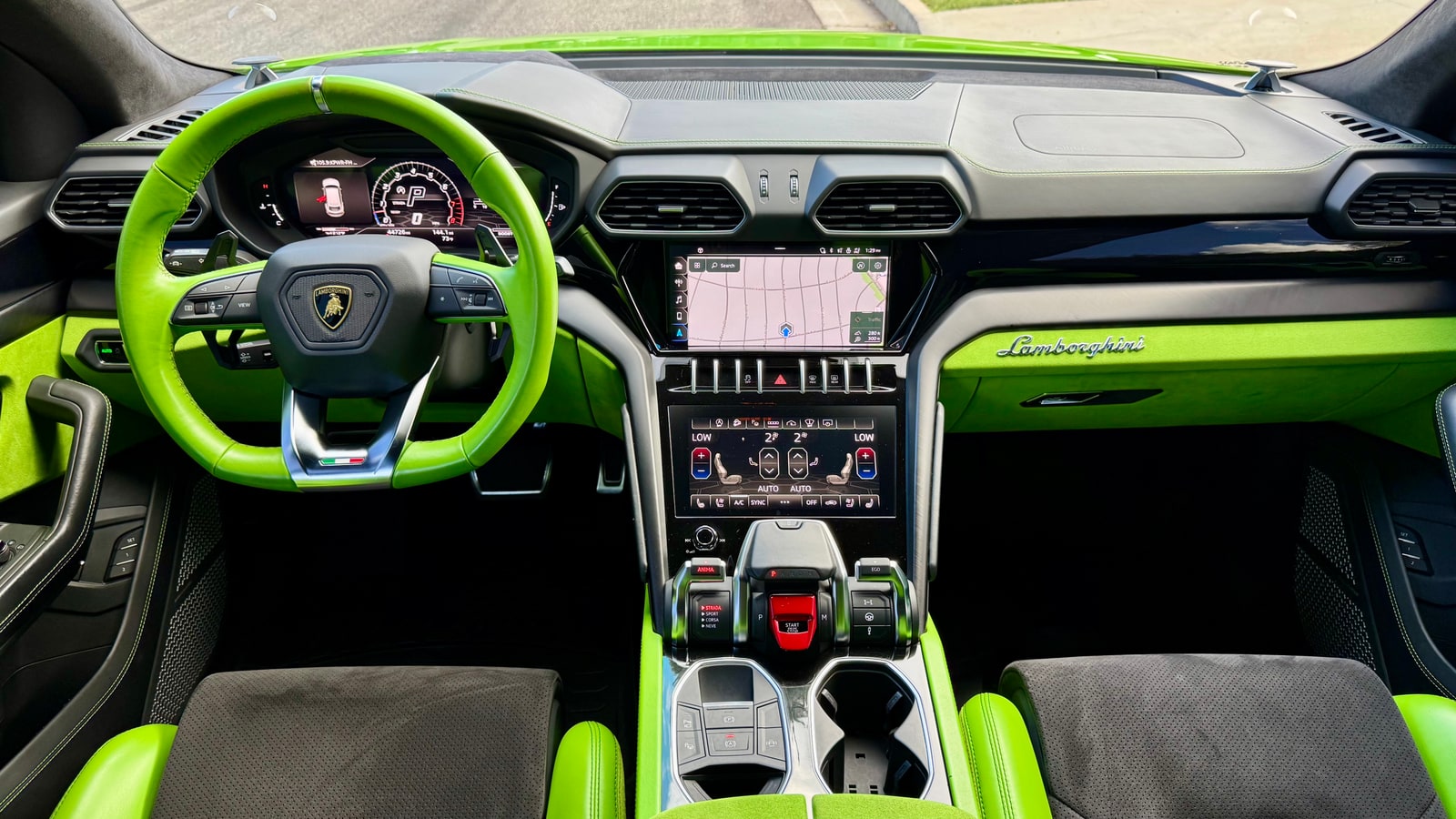 Green and black dashboard and steering wheel of the Lamborghini Urus