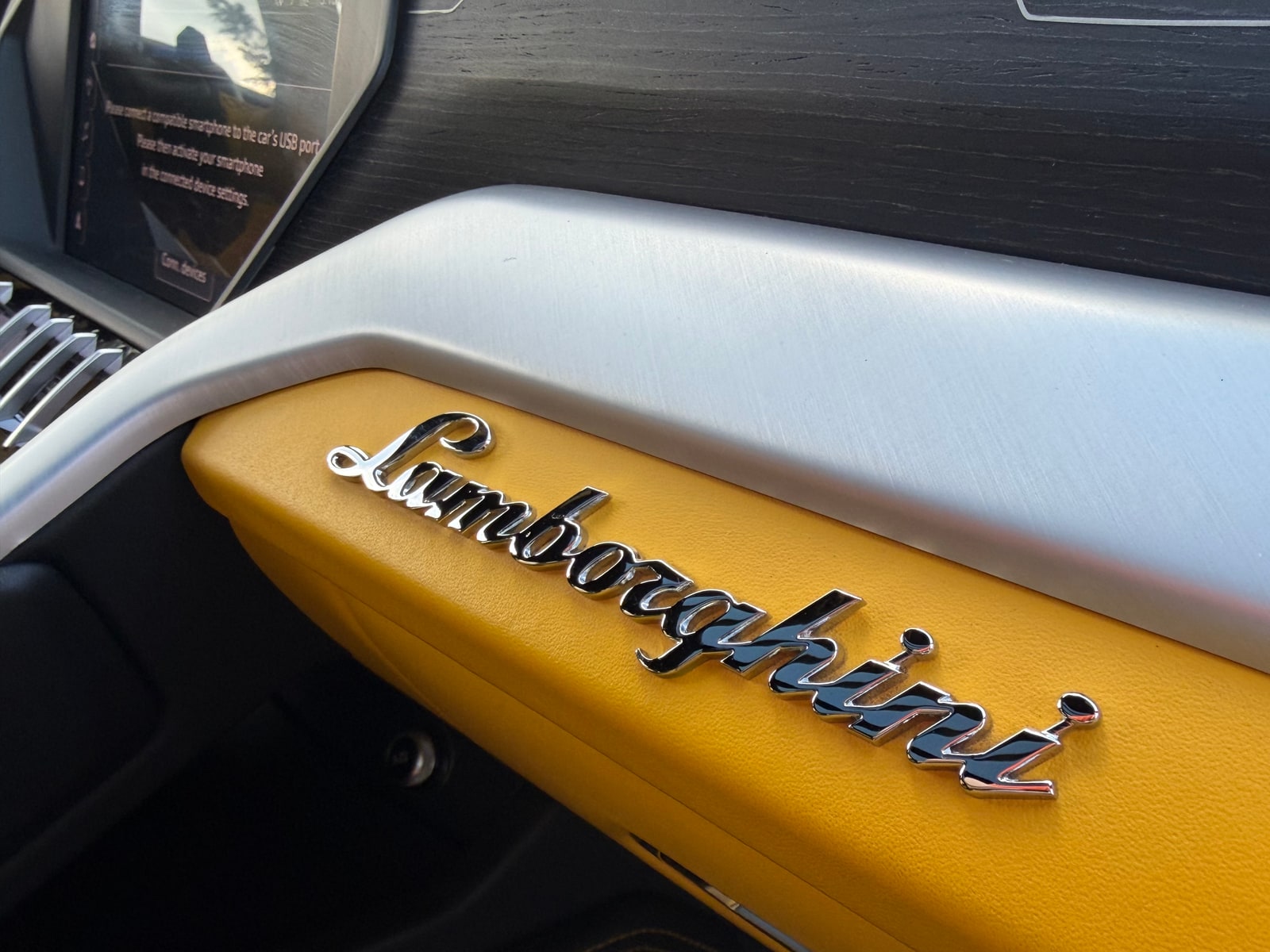 Lamborghini script embossed into the yellow dash panel of the Urus