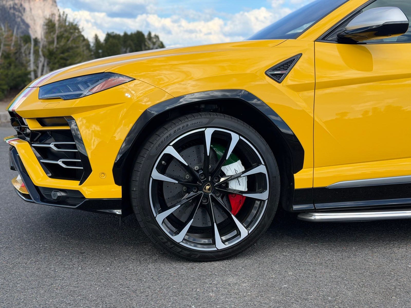 Front wing and wheel of the yellow Lamborghini Urus with a tricolour brake caliper