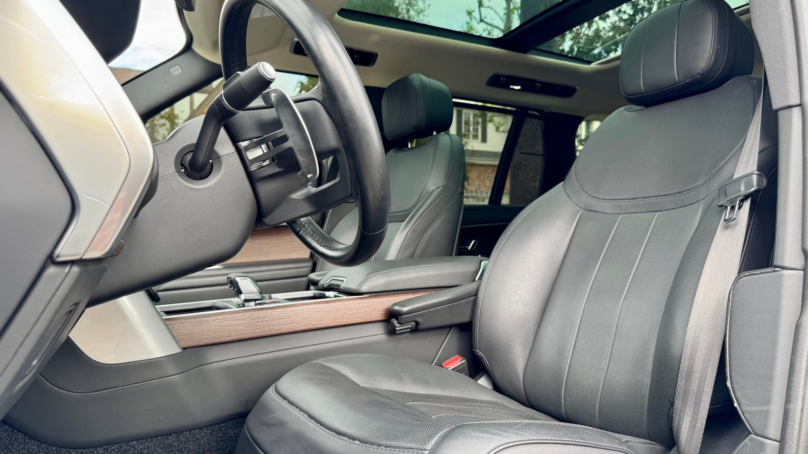 Black leather front seat of the Range Rover under the glass roof