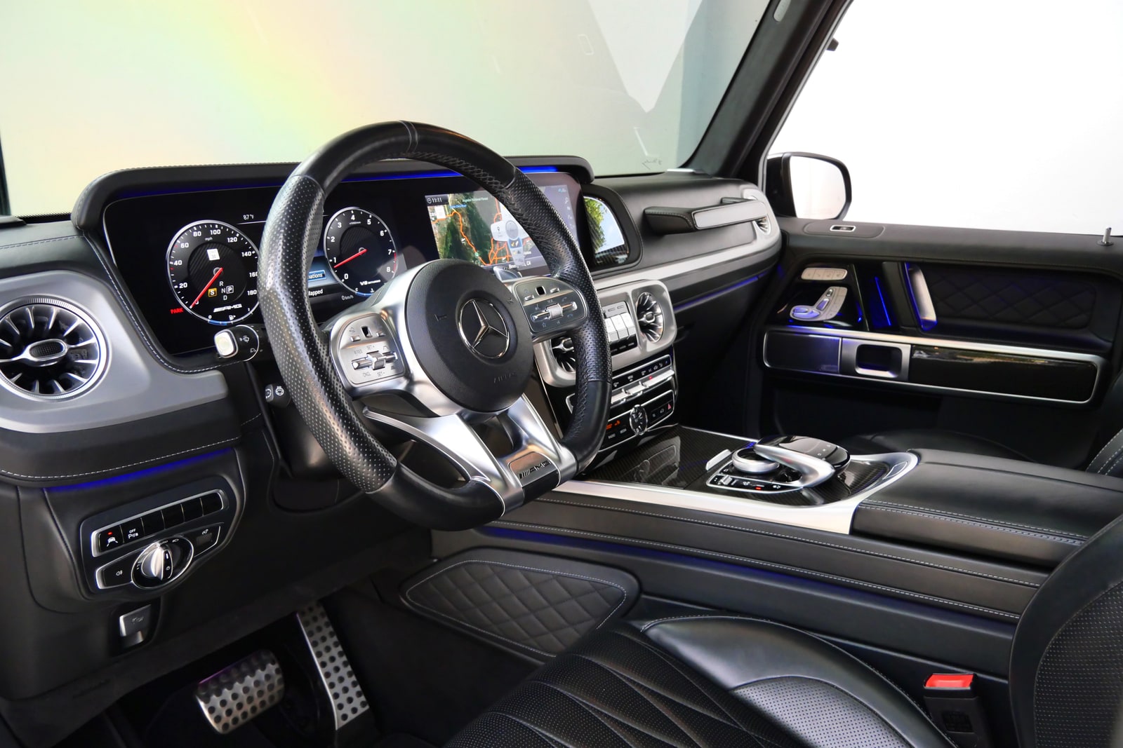Cabin of the Mercedes-AMG G 63 in black quilted leather with blue ambient light