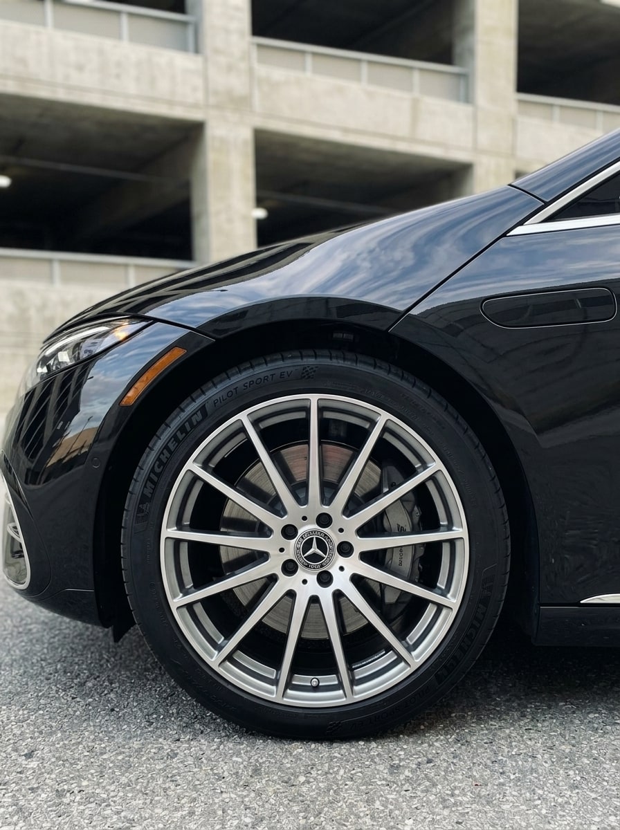 Front wheel and arch of the black Mercedes EQS