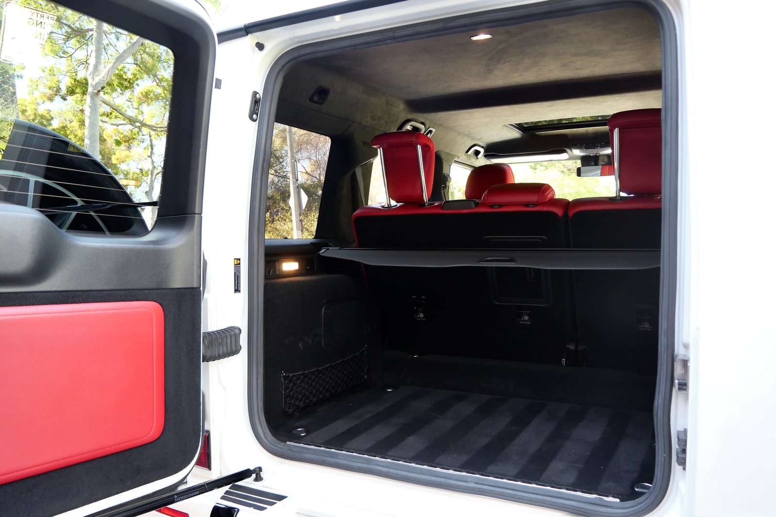Open side-hinged tailgate of the white Mercedes-Benz G 550