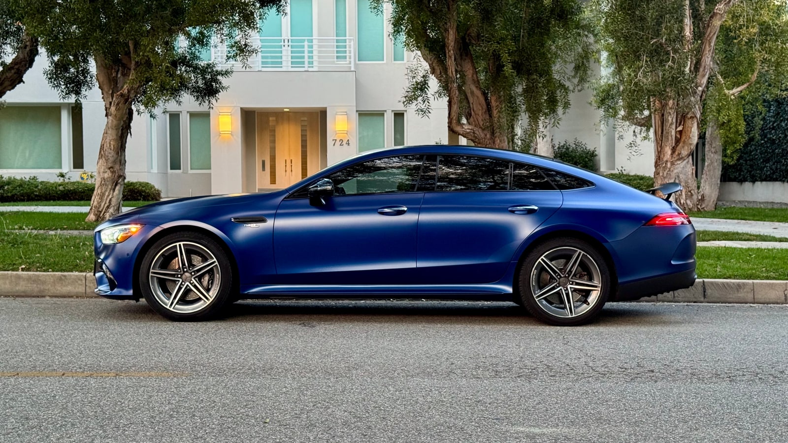 Blue Mercedes-AMG GT 43 from a front three-quarter on a residential street