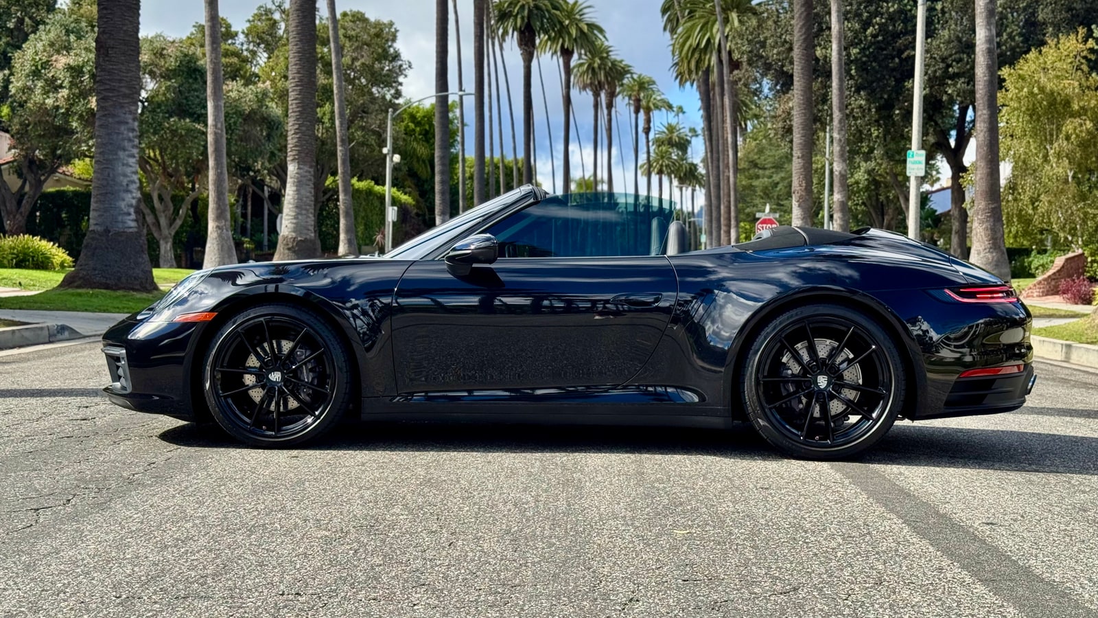 Black Porsche 911 Cabriolet in profile with the roof folded