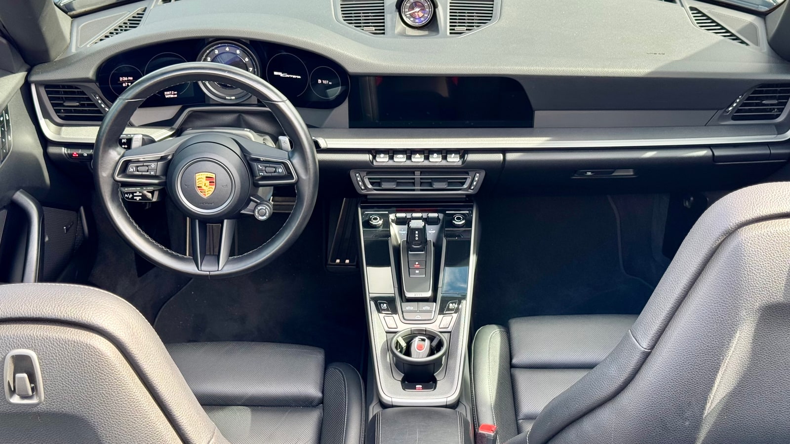 Black leather interior of the Porsche 911 Cabriolet seen from above with the roof open