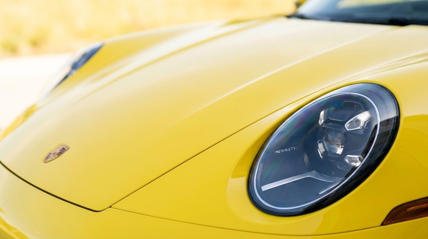 Round headlamp of the yellow Porsche 911