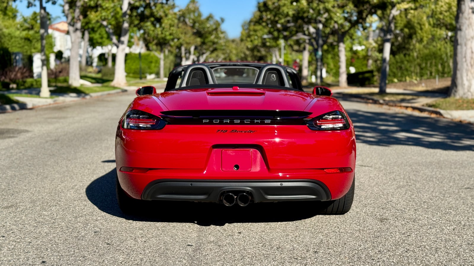 Rear of the red Porsche 718 Boxster with the light bar across the tail