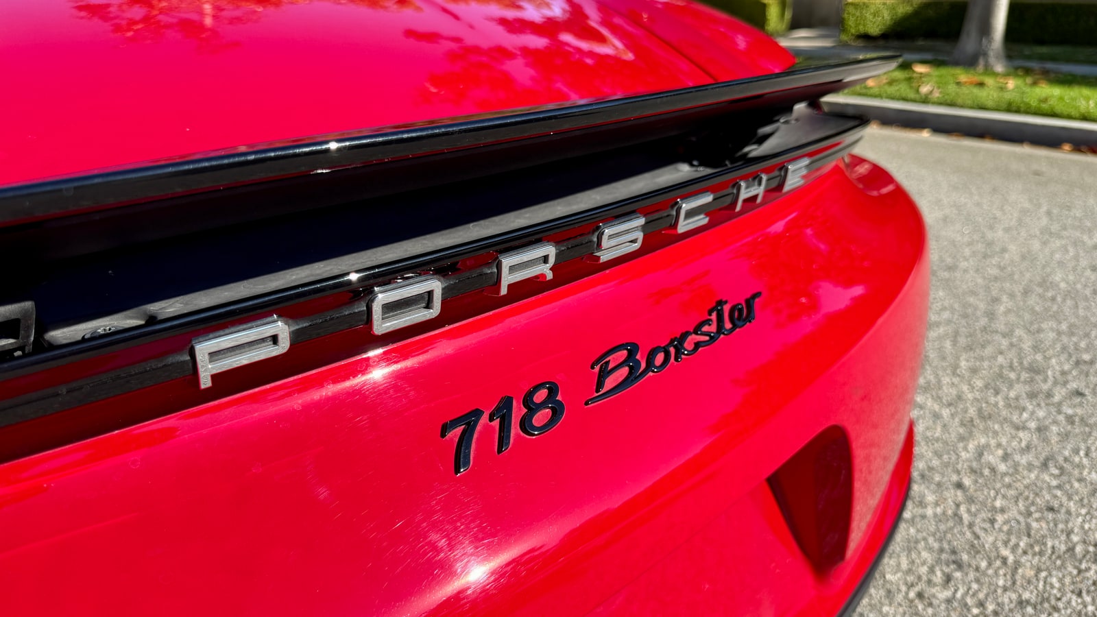 718 Boxster script on the rear deck of the red Porsche