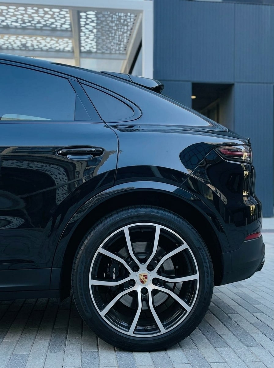 Rear wheel and fastback roofline of the black Porsche Cayenne Coupé