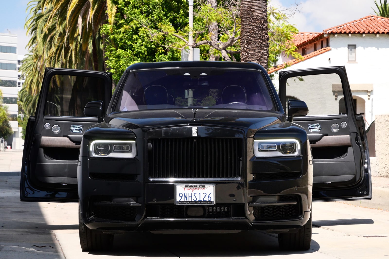 Black Rolls-Royce Cullinan with both coach doors open on a Beverly Hills street