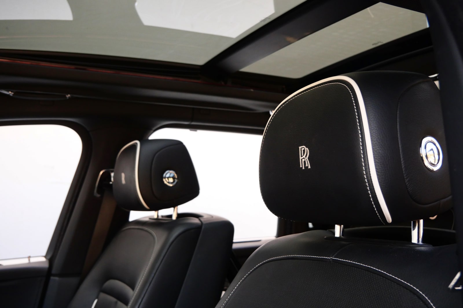 Panoramic glass roof above embroidered Rolls-Royce headrests in the Cullinan