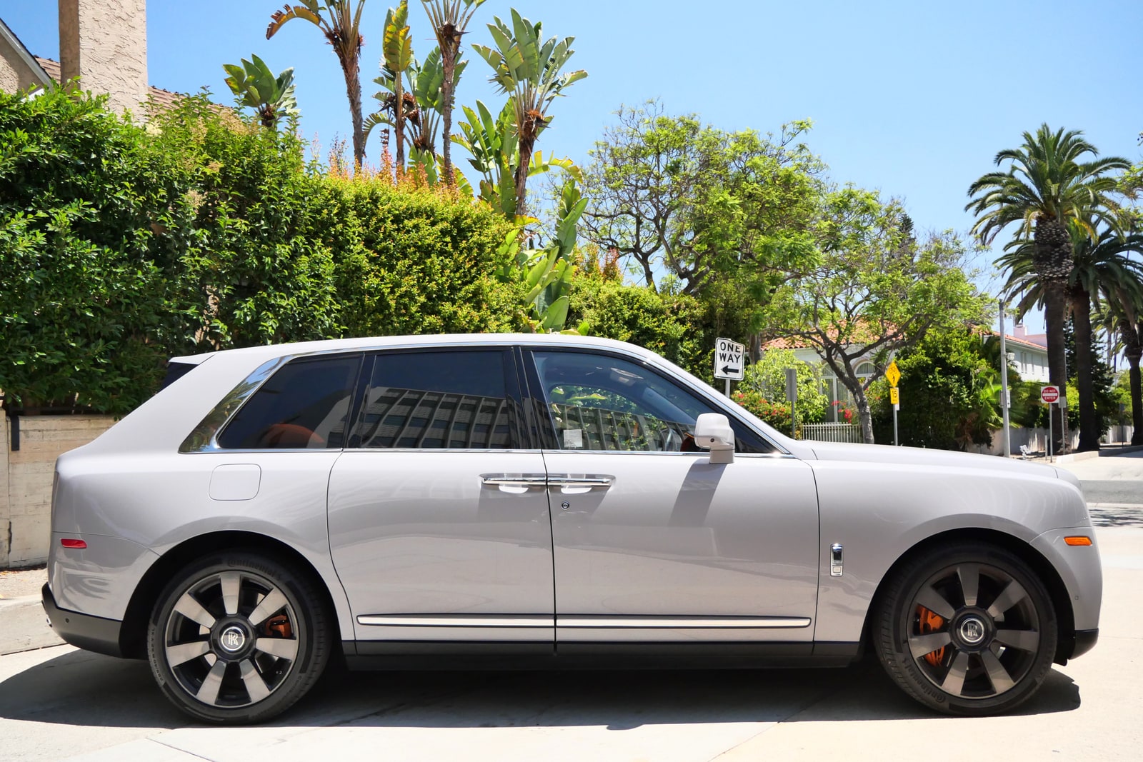 White Rolls-Royce Cullinan in profile at the kerb