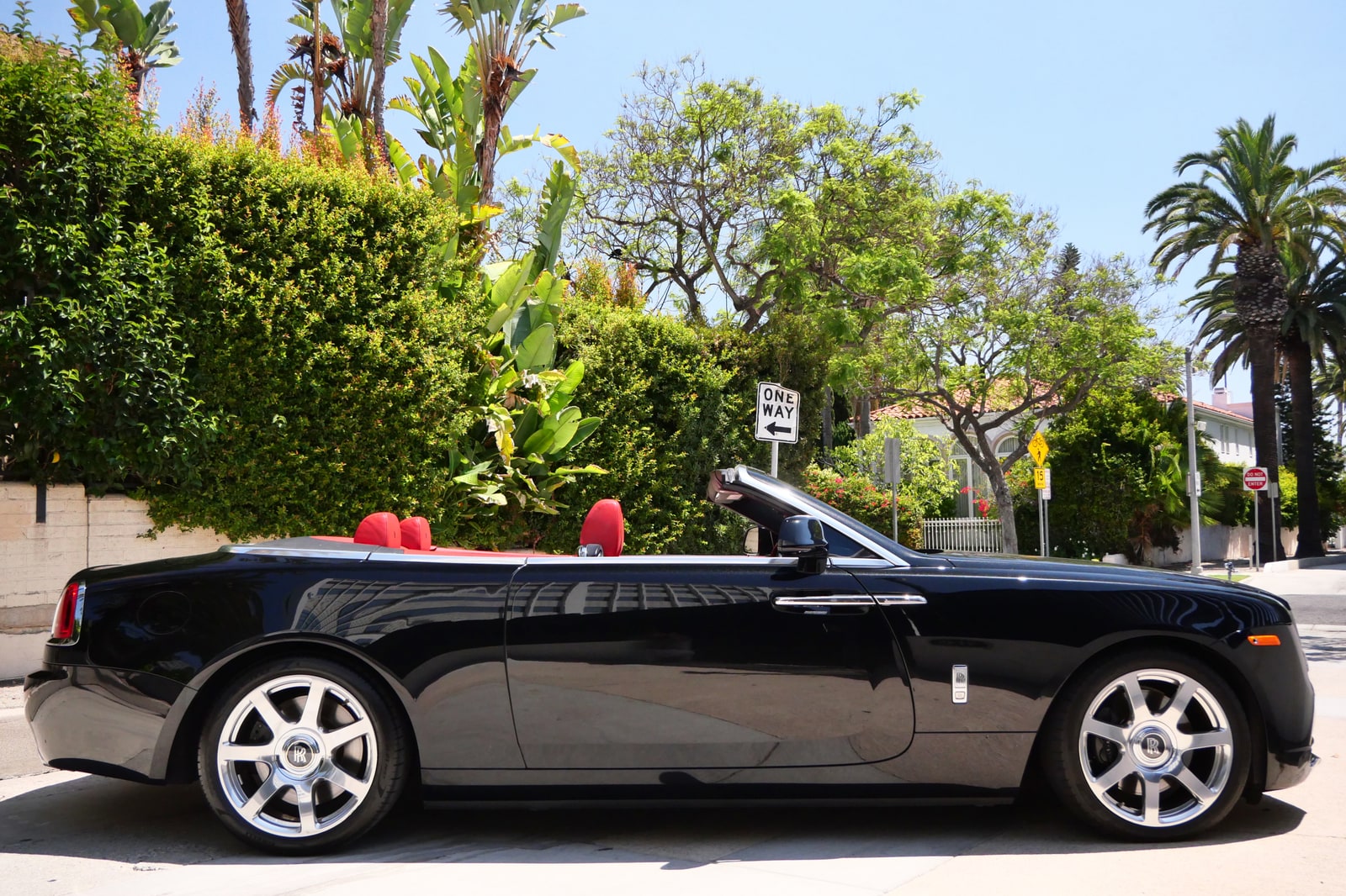 Side profile of the black Rolls-Royce Dawn with the roof down