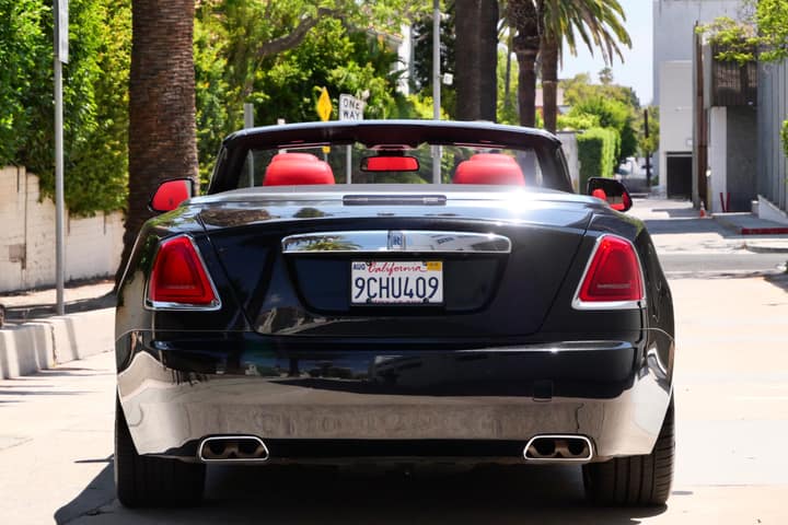 Rear view of a black Rolls-Royce Dawn convertible with the roof down