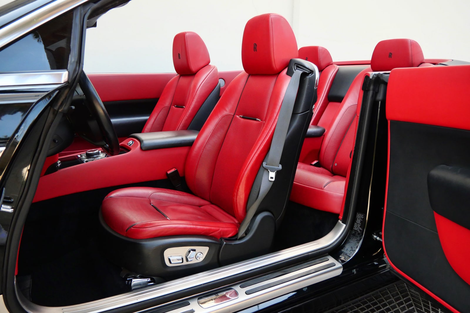 The full red leather cabin of the Rolls-Royce Dawn, four seats, through the open coach door