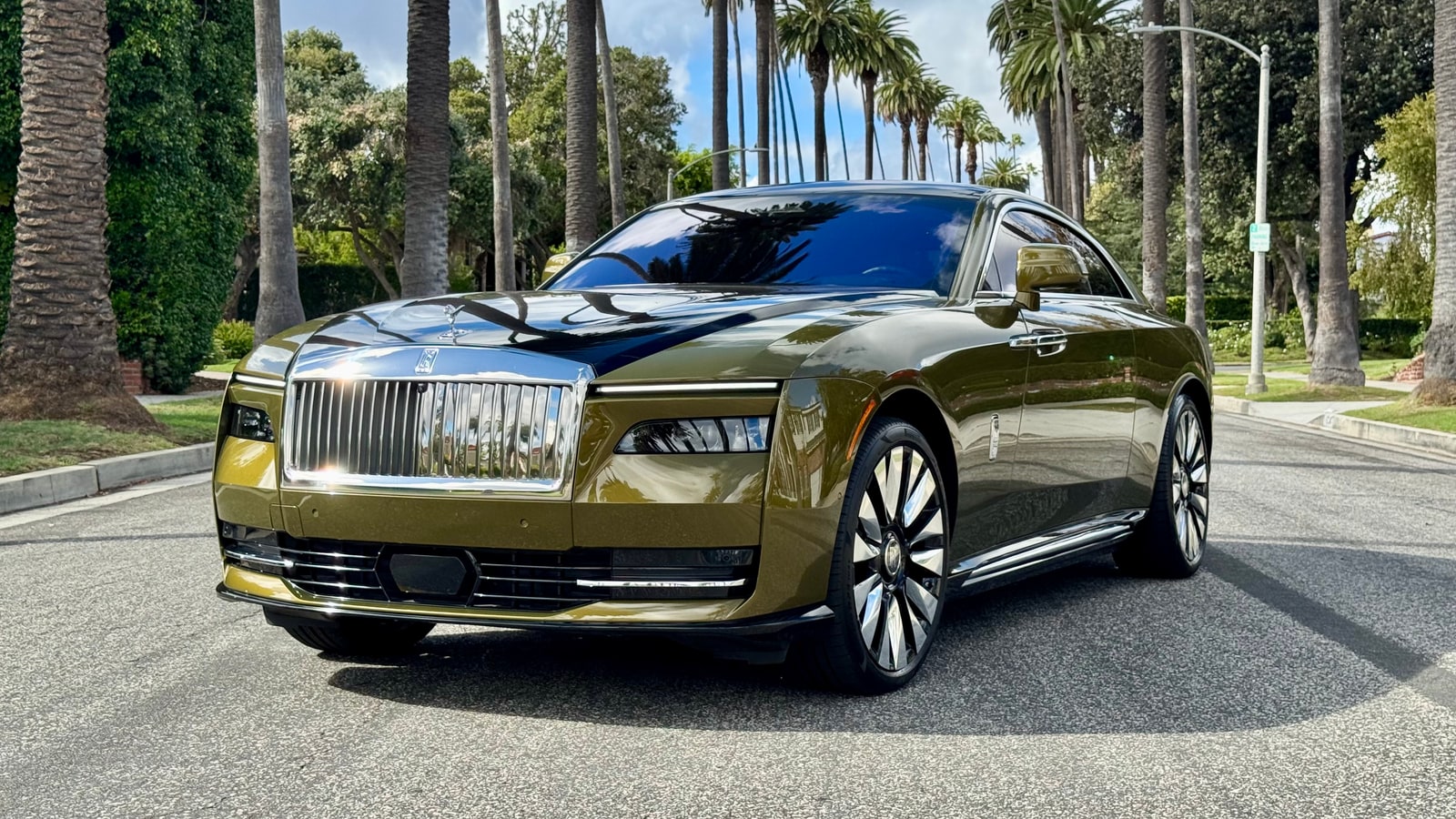Chartreuse Rolls-Royce Spectre from a front three-quarter on a palm-lined Beverly Hills street