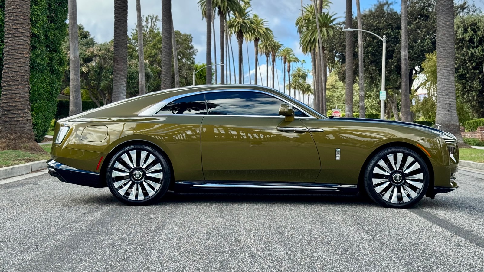 Rolls-Royce Spectre coupe in profile, olive-gold paint and polished wheels