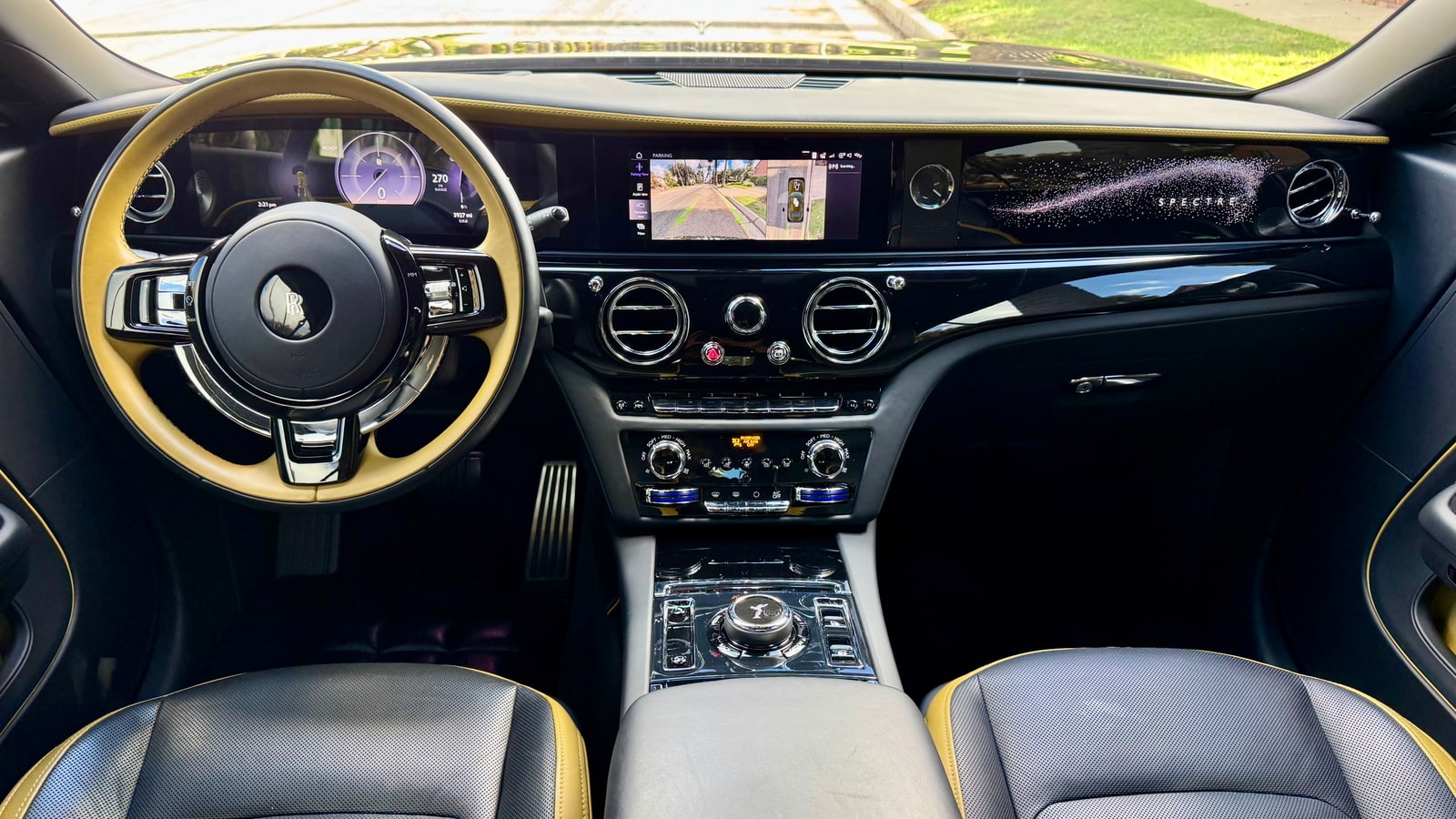 Dashboard and yellow-rimmed steering wheel of the Rolls-Royce Spectre seen from above