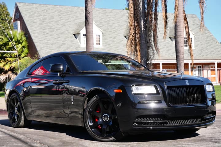 Black Rolls-Royce Wraith photographed head-on beneath palm trees
