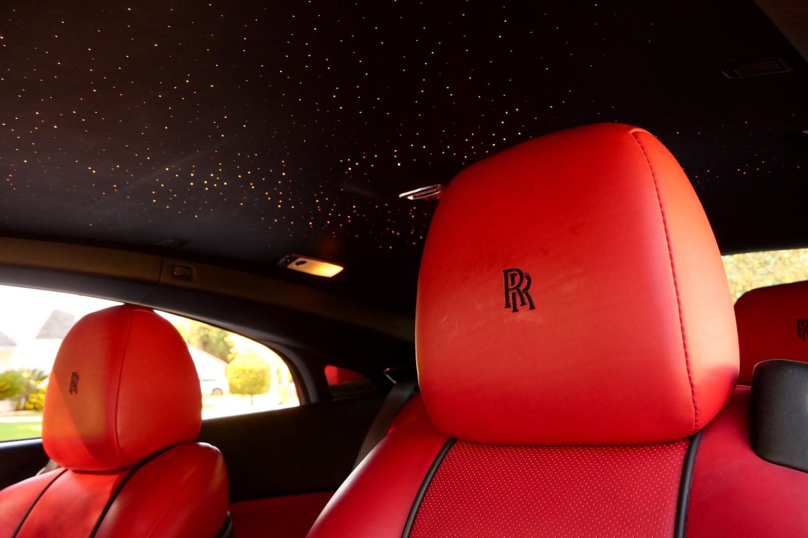 Starlight headliner above the red leather headrests of the Rolls-Royce Wraith