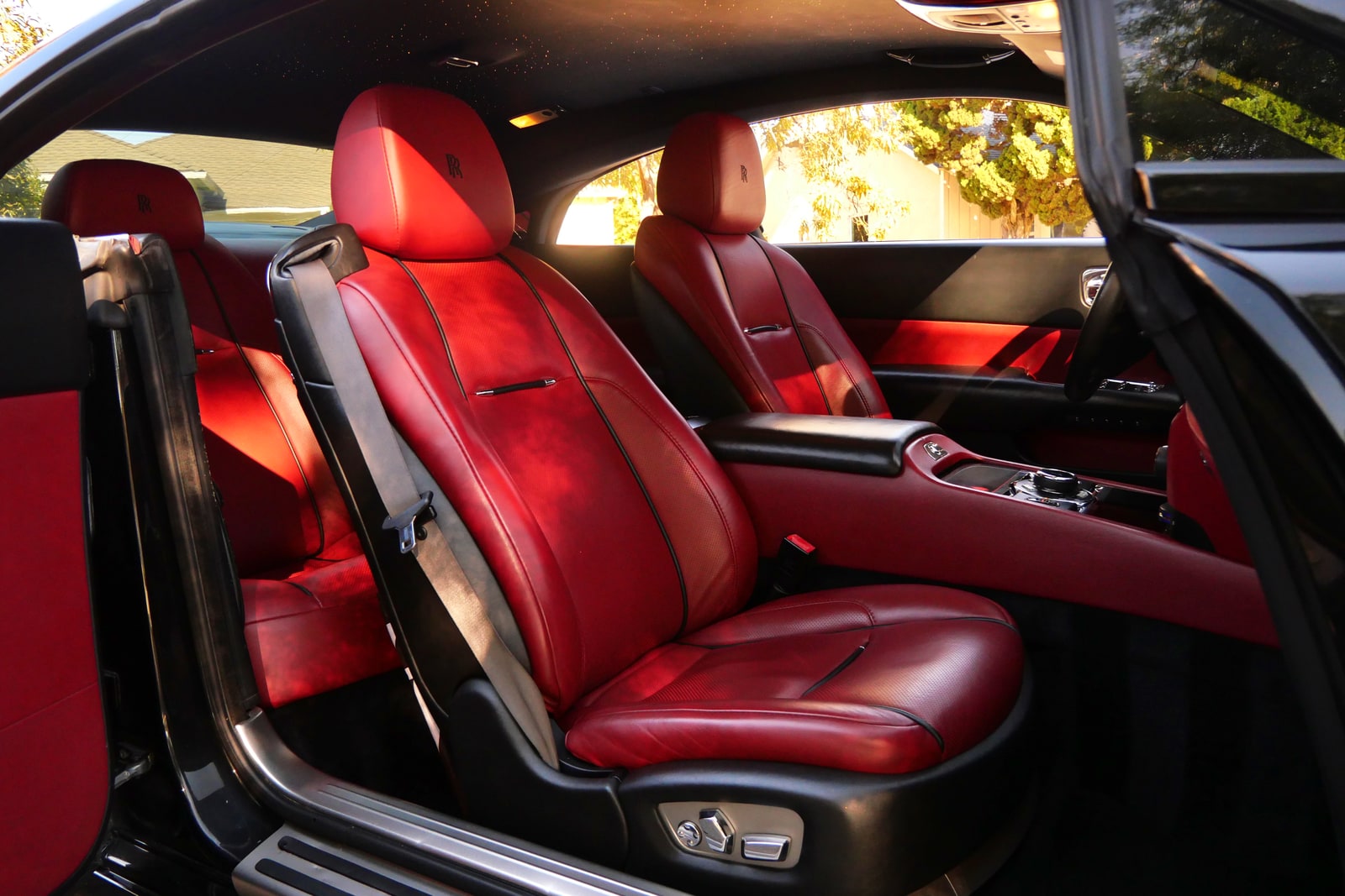 Red leather rear seats of the Rolls-Royce Wraith seen through the open coach door